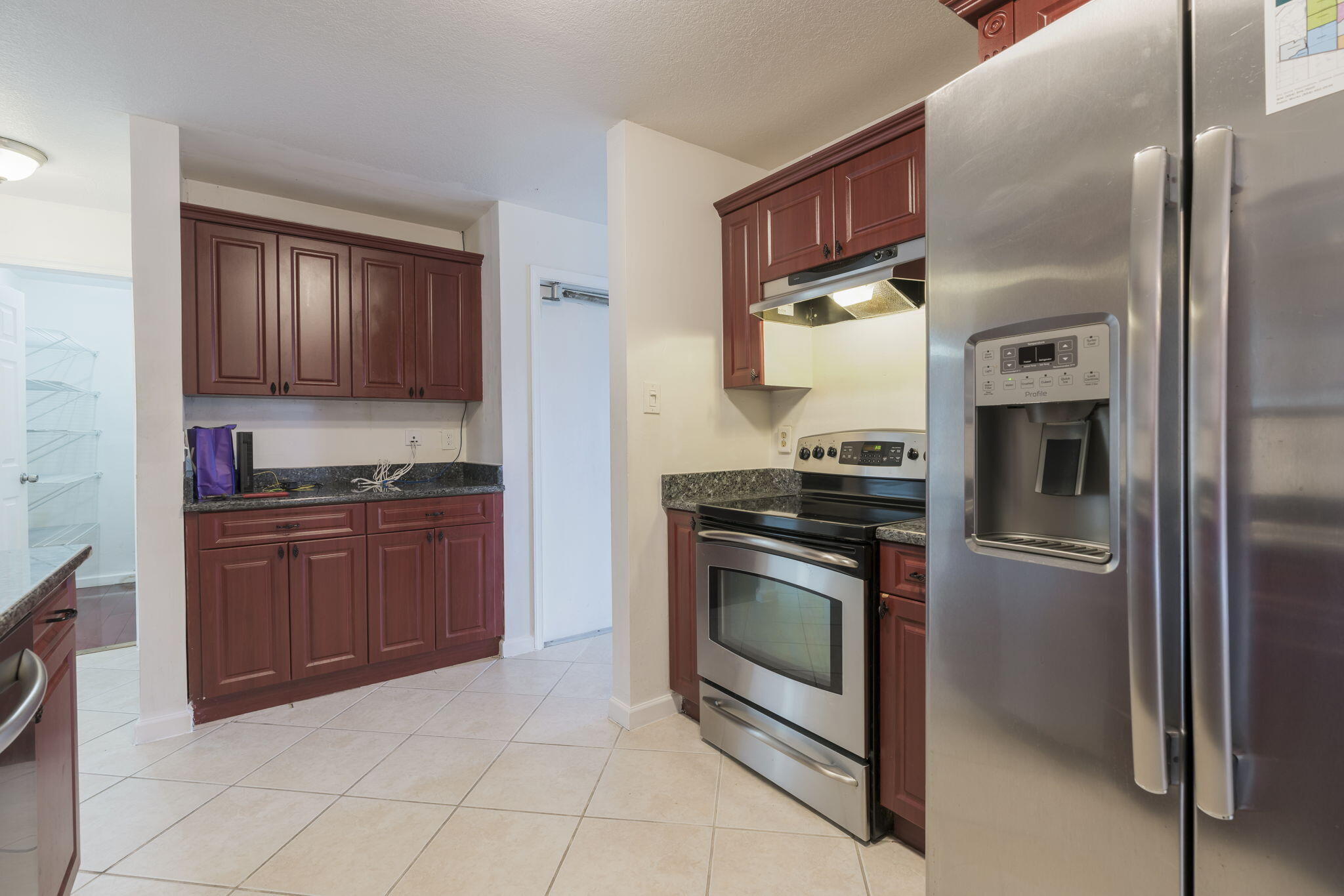 1141 Northwest 90th Way Plantation, FL 33322 - Photo 40 of 75 a kitchen with granite countertop stainless steel appliances and wooden cabinets