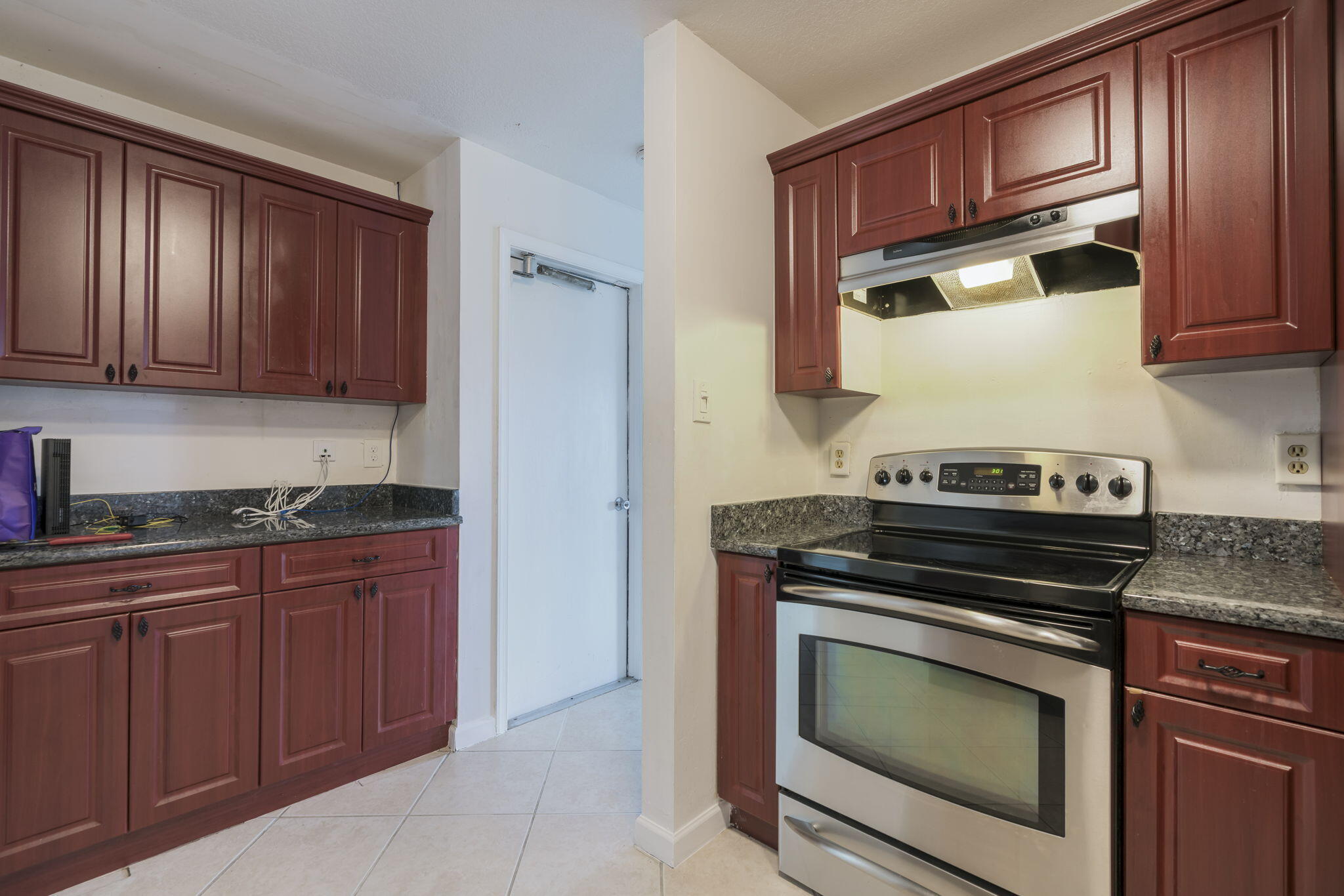 1141 Northwest 90th Way Plantation, FL 33322 - Photo 41 of 75 a kitchen with granite countertop wooden cabinets and a stove top oven