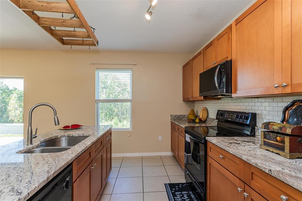 2470 Valhalla Drive Tavares, FL 32778 - Photo 11 of 26 a kitchen with granite countertop a sink a stove and cabinets