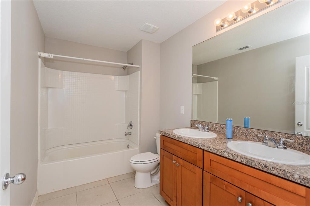 2470 Valhalla Drive Tavares, FL 32778 - Photo 22 of 26 a bathroom with a granite countertop sink mirror toilet and bathtub