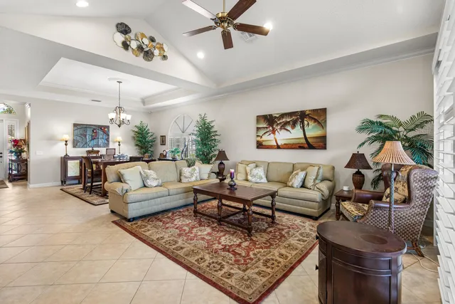 a large kitchen with granite countertop a stove a sink a refrigerator and white cabinets with wooden floor