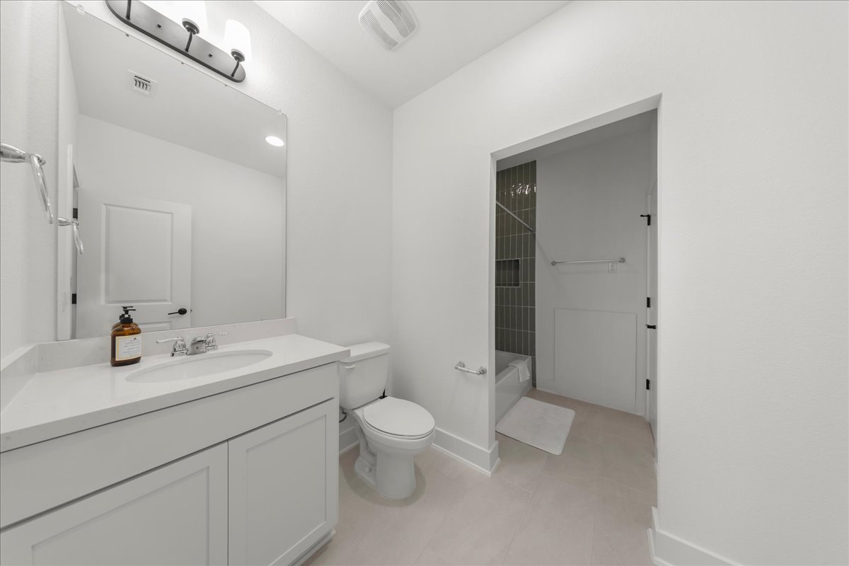 8700 Olmsted Way Austin, TX 78744 - Photo 27 of 40 Bathroom with vanity, washtub / shower combination, and light tile patterned floors