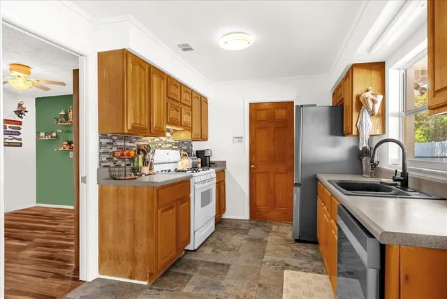 a kitchen with stainless steel appliances granite countertop a sink stove and refrigerator