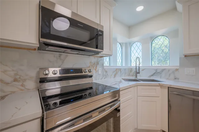 a kitchen with stainless steel appliances granite countertop a stove and a sink