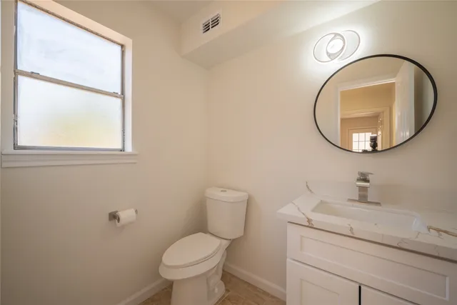 a bathroom with a toilet a sink and a mirror