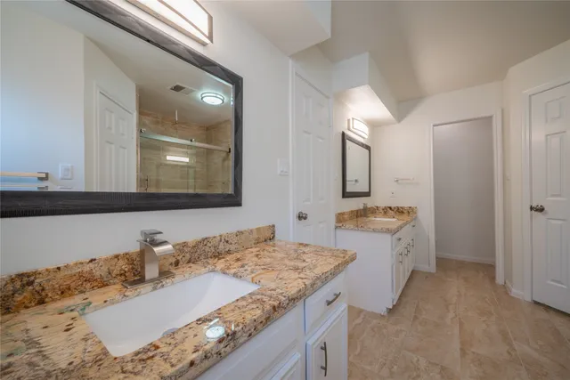 a bathroom with a granite countertop sink and a mirror