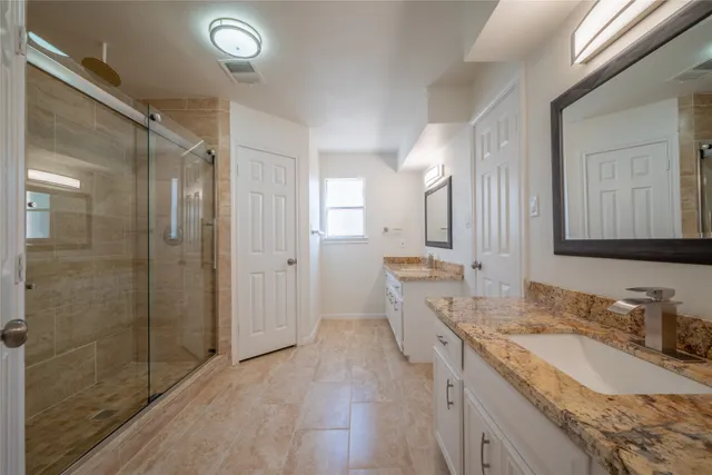 a bathroom with a granite countertop sink mirror and double