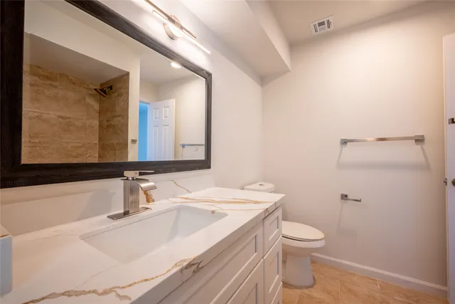 a bathroom with a sink toilet and mirror