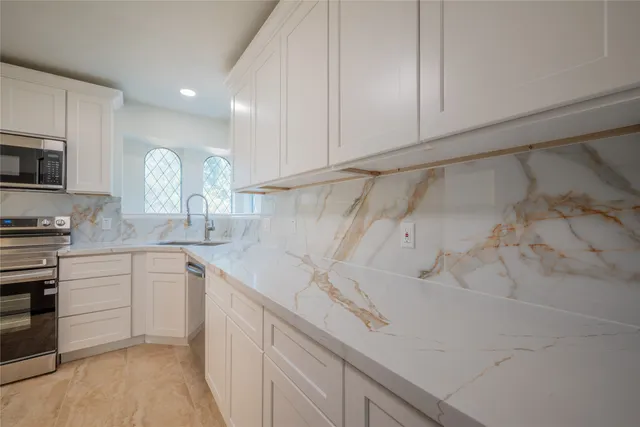 a kitchen with a sink cabinets and stainless steel appliances