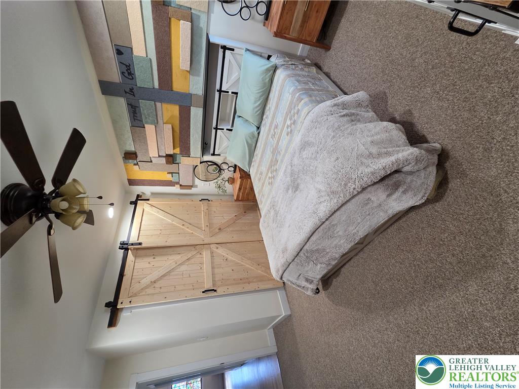 89 Short Ridge Road Albrightsville, PA 18210 - Photo 28 of 71 A comfortable bedroom features soft carpeting and sliding barn doors that open to the interior.