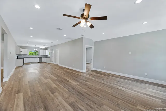 a view of empty room with wooden floor and window