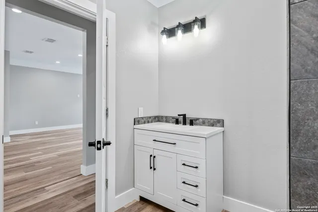 a bathroom with a sink vanity and a mirror