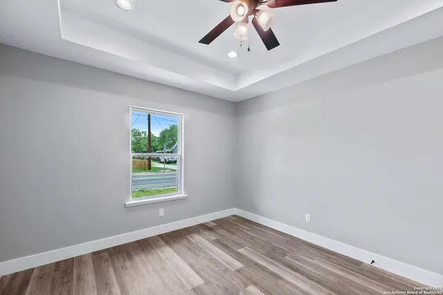 an empty room with a window and a ceiling fan
