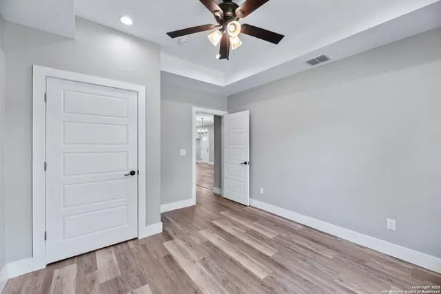 wooden floor in an empty room with a ceiling fan