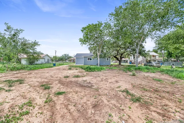 a view of a street with a house in the background