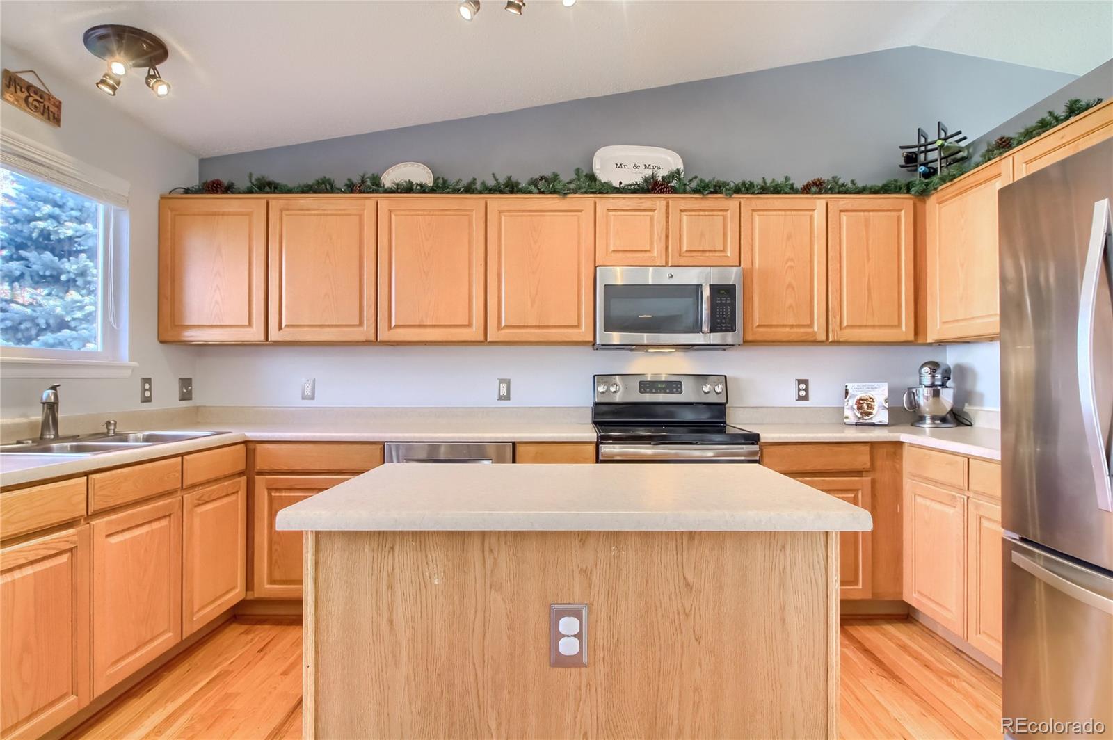 1031 Timbervale Trail Highlands Ranch, CO 80129 - Photo 11 of 34 a kitchen with stainless steel appliances a microwave sink refrigerator and cabinets