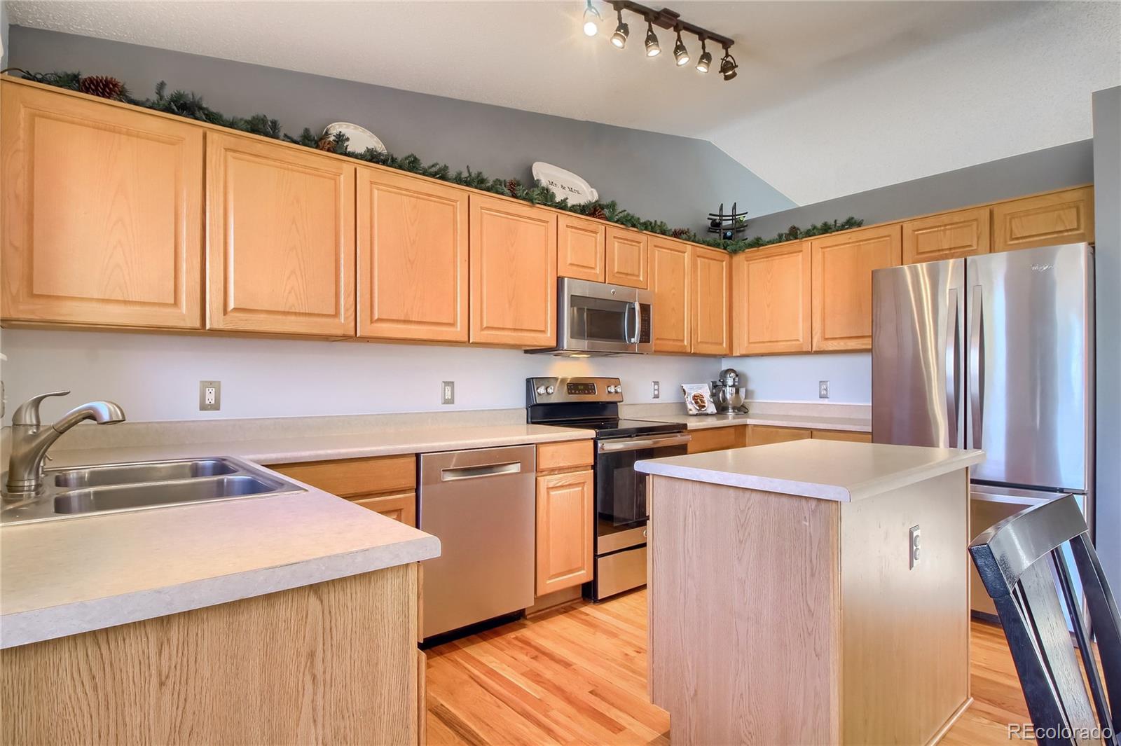1031 Timbervale Trail Highlands Ranch, CO 80129 - Photo 12 of 34 a kitchen with stainless steel appliances granite countertop a sink a stove and a refrigerator