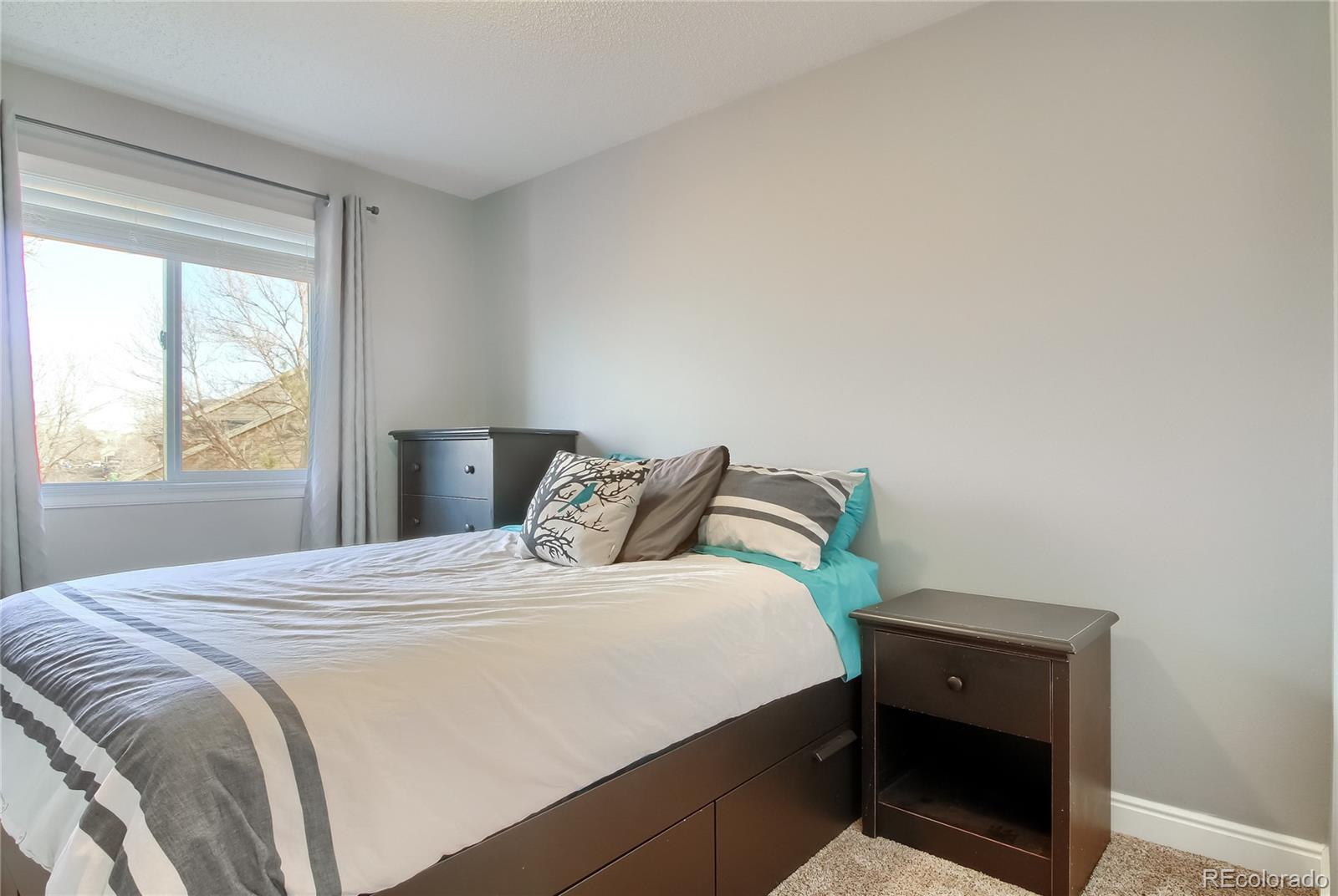 1031 Timbervale Trail Highlands Ranch, CO 80129 - Photo 19 of 34 a bedroom with a bed and a window