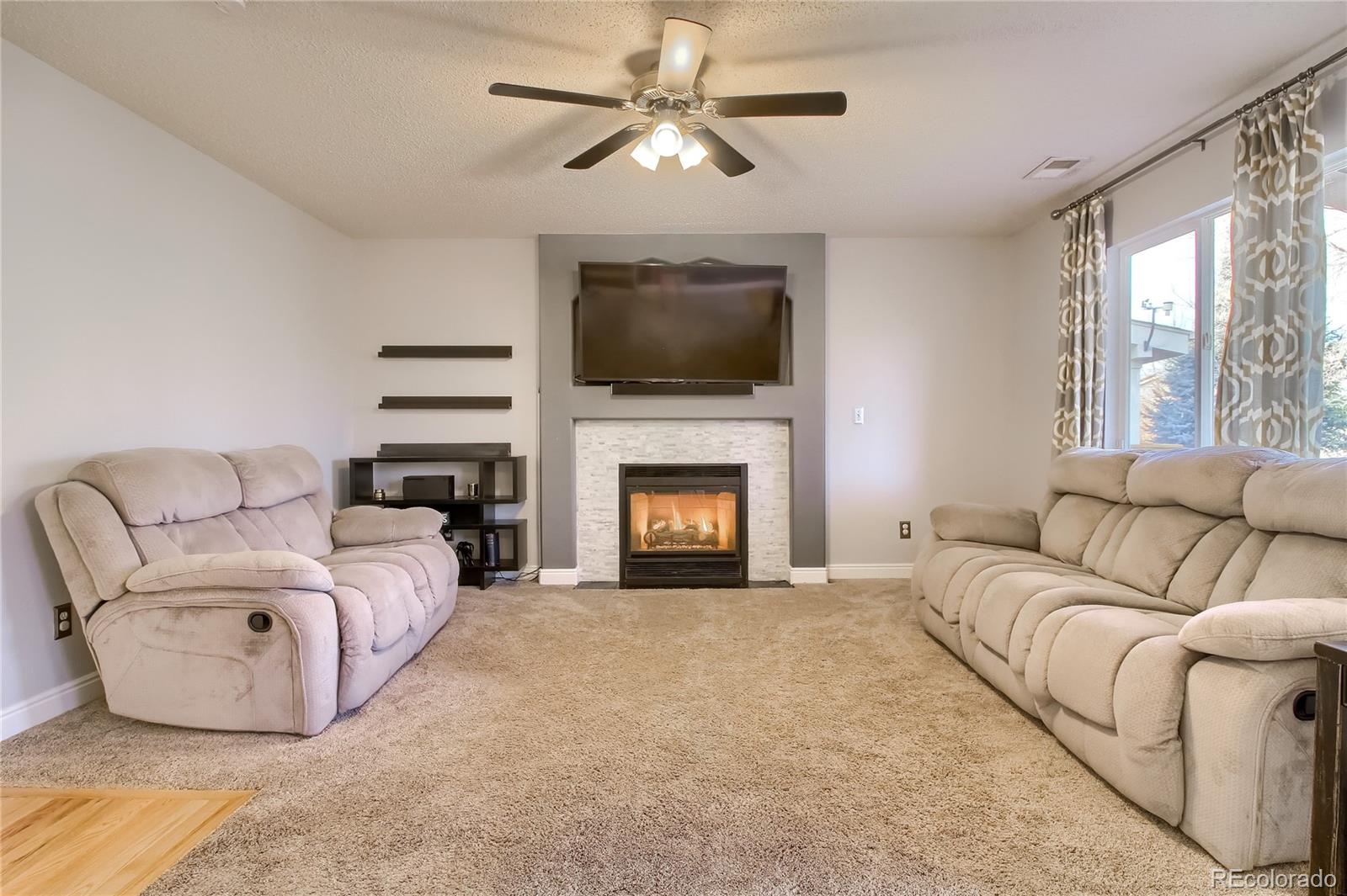 1031 Timbervale Trail Highlands Ranch, CO 80129 - Photo 6 of 34 a living room with furniture and a fireplace
