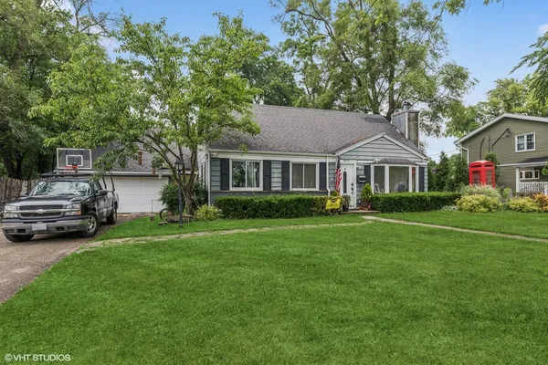 a front view of a house with a garden and trees