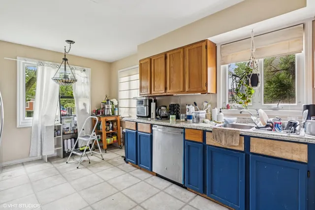 a kitchen with stainless steel appliances granite countertop a stove top oven a sink dishwasher and a refrigerator