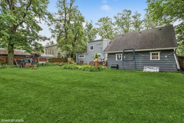 a view of a brick house with a big yard and large trees