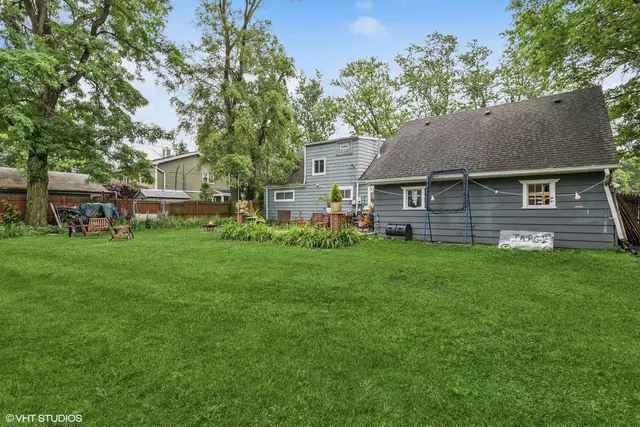 a view of a brick house with a big yard and large trees