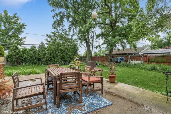 a view of a chairs and table in backyard of the house