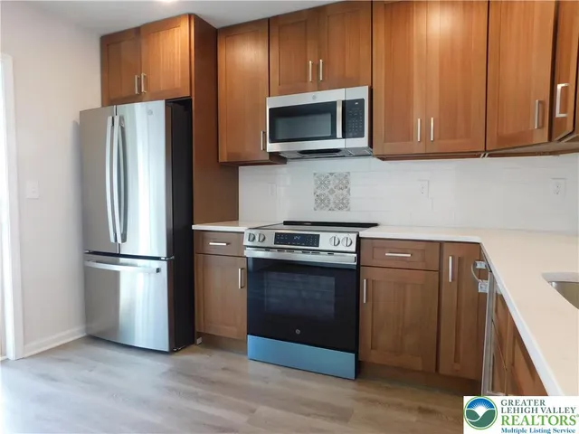 a kitchen with stainless steel appliances granite countertop a refrigerator microwave and sink