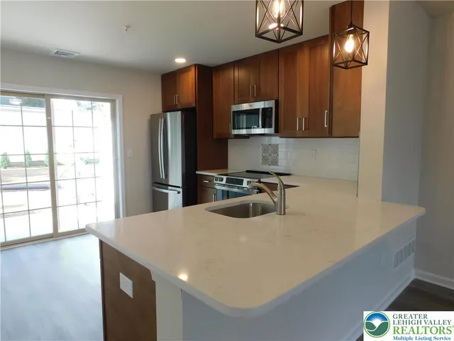 a kitchen with stainless steel appliances a microwave a sink and cabinets