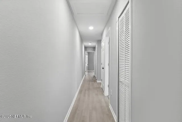 a view of a hallway with wooden floor
