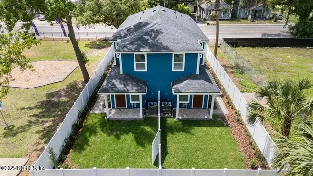 a aerial view of a house with swimming pool and large trees