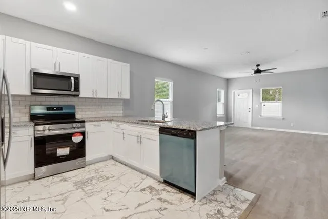 a kitchen with granite countertop a stove top oven microwave and cabinets