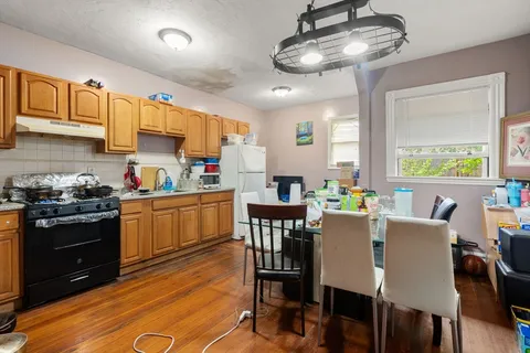 a kitchen with a dining table chairs stainless steel appliances and cabinets