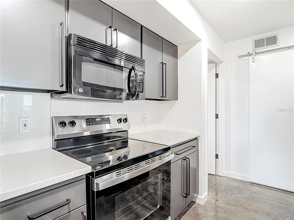 5722 Biscayne Court, Unit 103 New Port Richey, FL 34652 - Photo 19 of 99 a kitchen with a stove microwave and sink