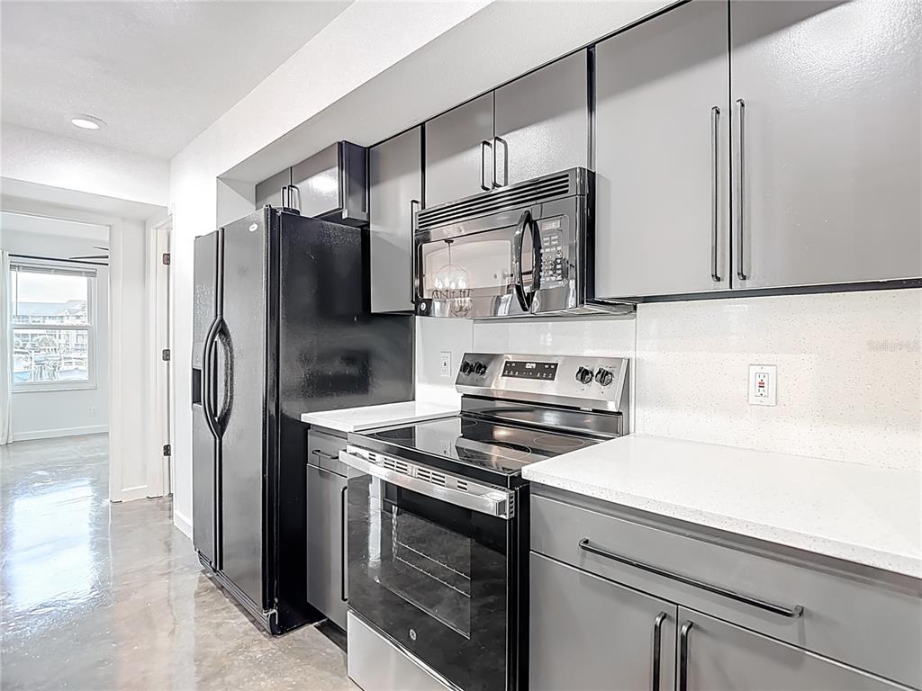 5722 Biscayne Court, Unit 103 New Port Richey, FL 34652 - Photo 21 of 99 a kitchen with stainless steel appliances a stove and a refrigerator