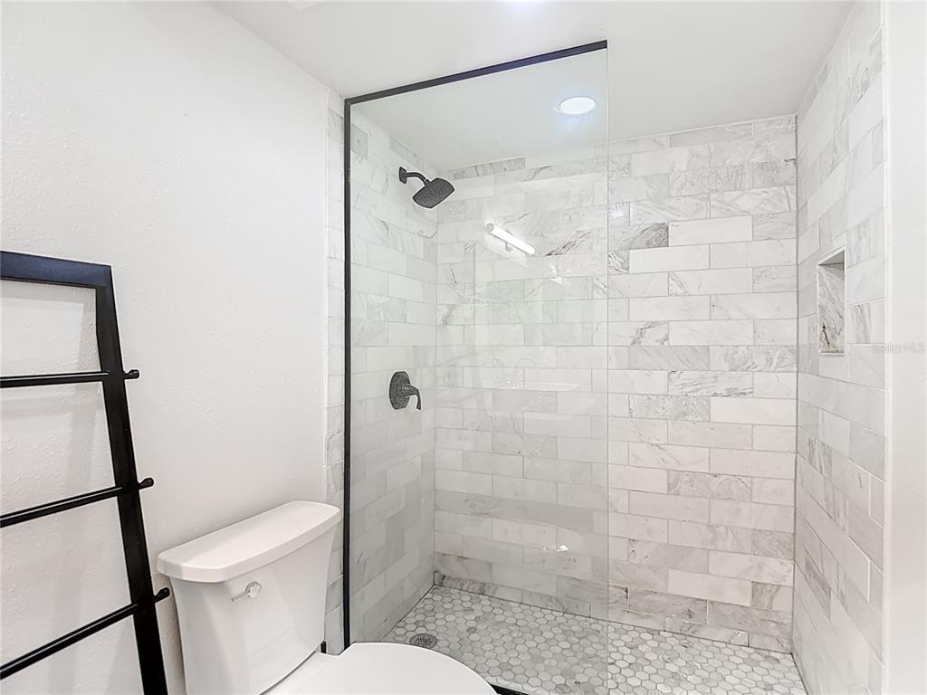 5722 Biscayne Court, Unit 103 New Port Richey, FL 34652 - Photo 26 of 99 a bathroom with a shower a toilet and sink