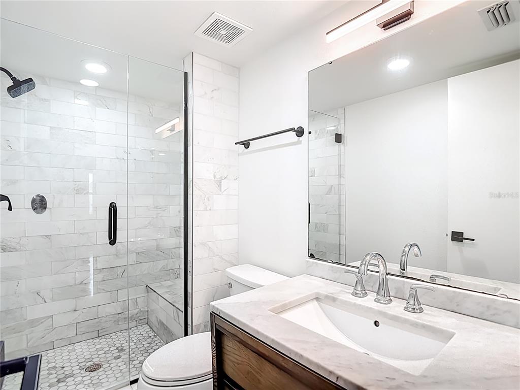 5722 Biscayne Court, Unit 103 New Port Richey, FL 34652 - Photo 32 of 99 a bathroom with a sink toilet vanity and shower