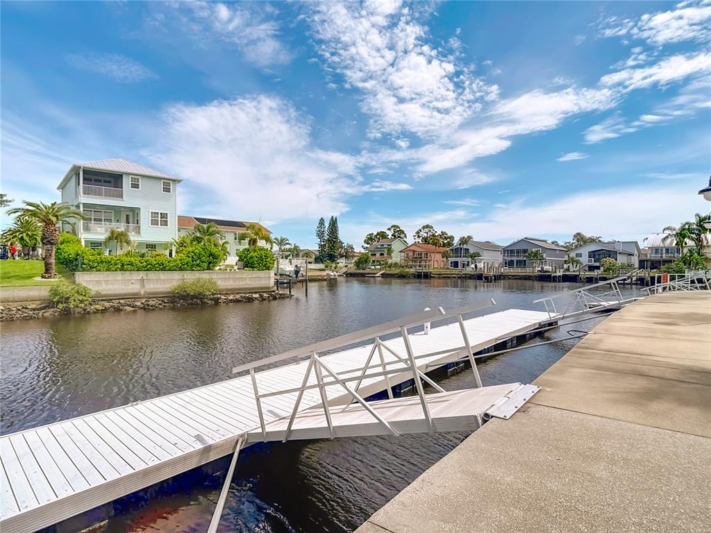 5722 Biscayne Court, Unit 103 New Port Richey, FL 34652 - Photo 81 of 99 a view of a lake with a bench next to a lake