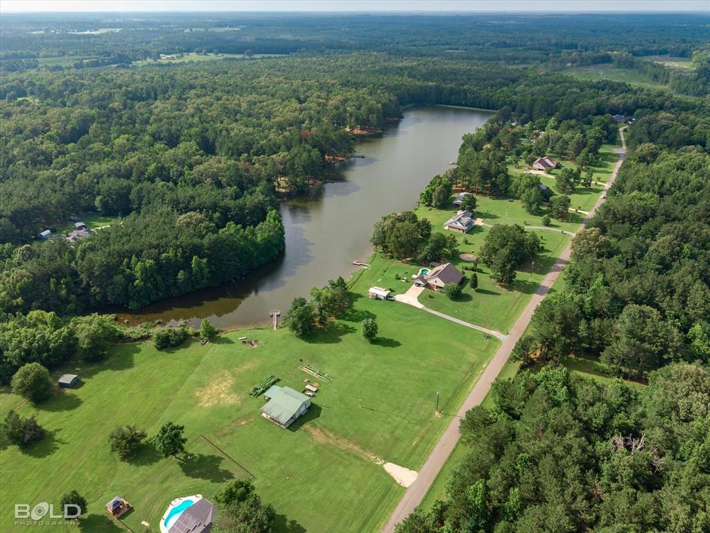 0 Twin Lakes Road Mansfield, LA 71052 - Photo 26 of 28 Lakefront property featuring a private dock, expansive green space, surrounding mature trees, and a private inground swimming pool