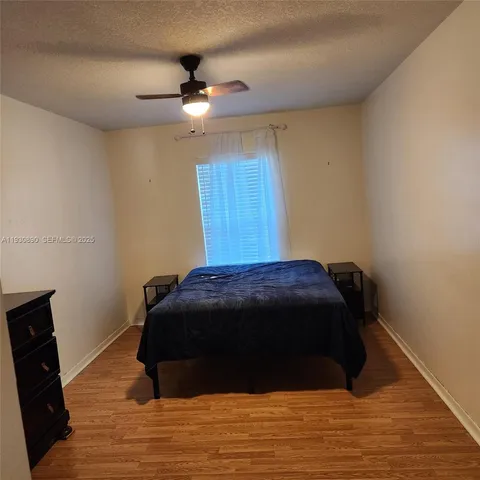 a bedroom with a bed and a ceiling fan