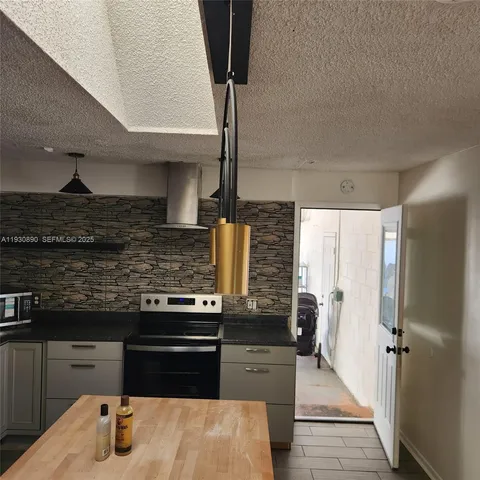 a kitchen with stainless steel appliances granite countertop a stove and a refrigerator