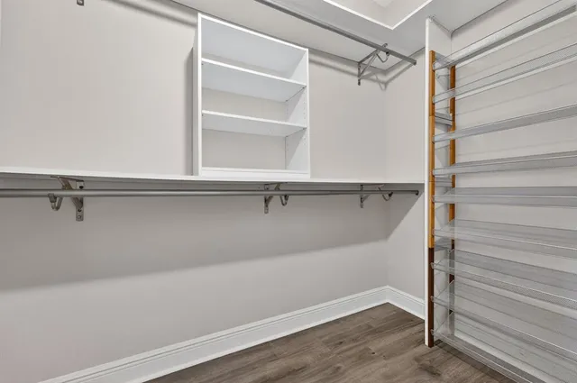 a view of an empty room with wooden floor