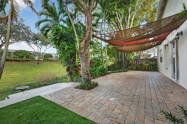 an aerial view of a house with a yard and a large tree