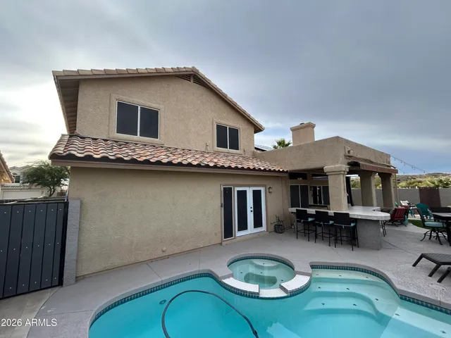 a backyard of a house with barbeque oven table and chairs