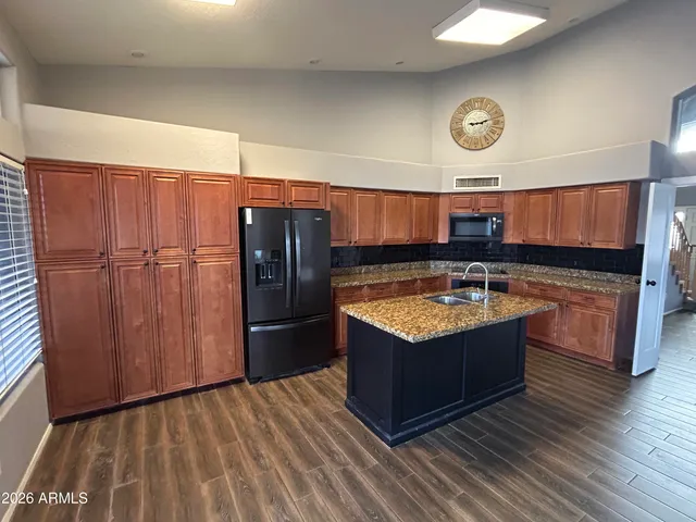 a kitchen with stainless steel appliances granite countertop a sink stove and refrigerator