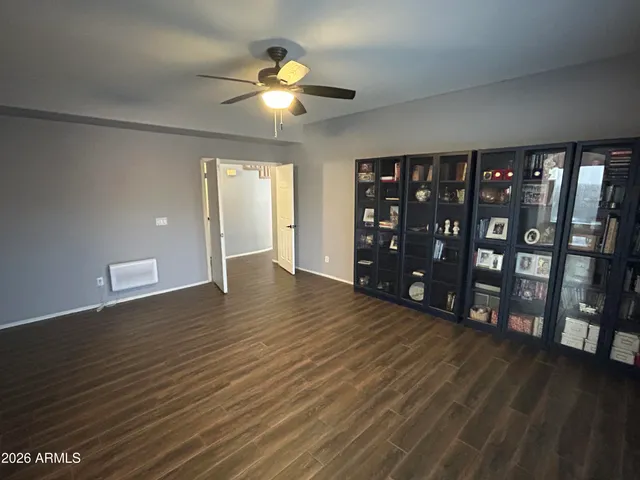 a view of an empty room with window and wooden floor