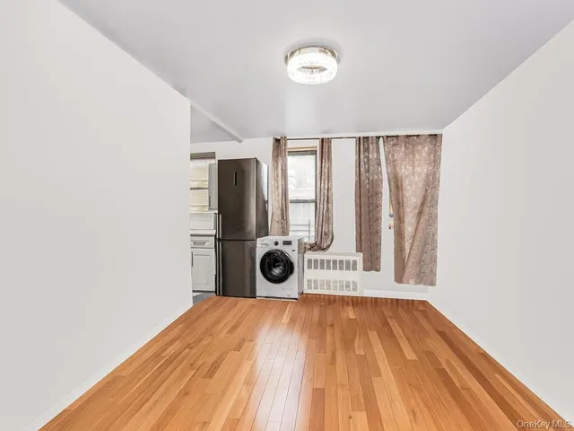 a view of a room with wooden floor and a ceiling fan