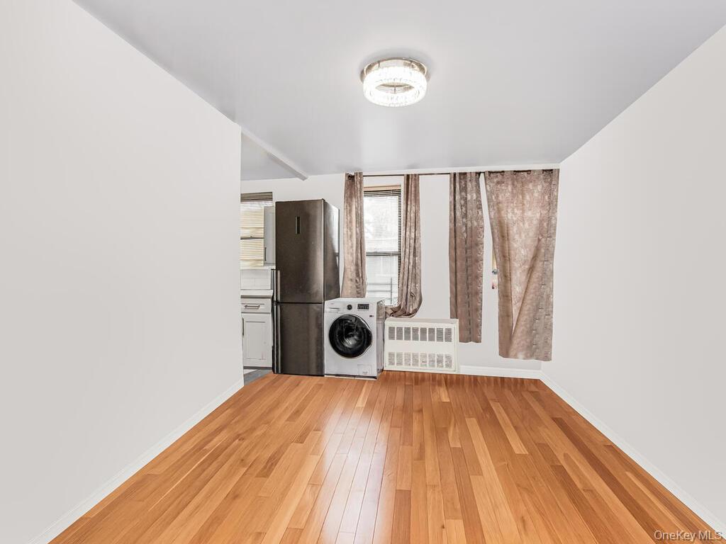 829 Adee Avenue, Unit 2L Bronx, NY 10467 - Photo 5 of 9 a view of a room with wooden floor and a ceiling fan