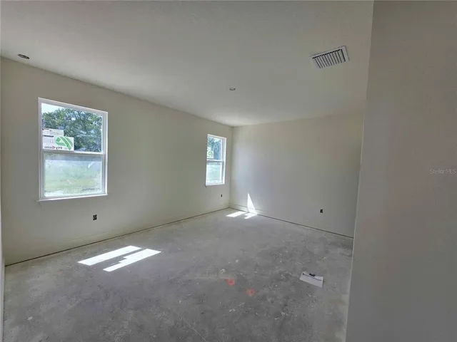 an empty room with windows and closet